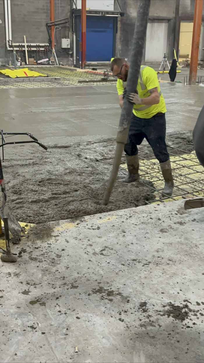 Worker pumping concrete for a commercial slab