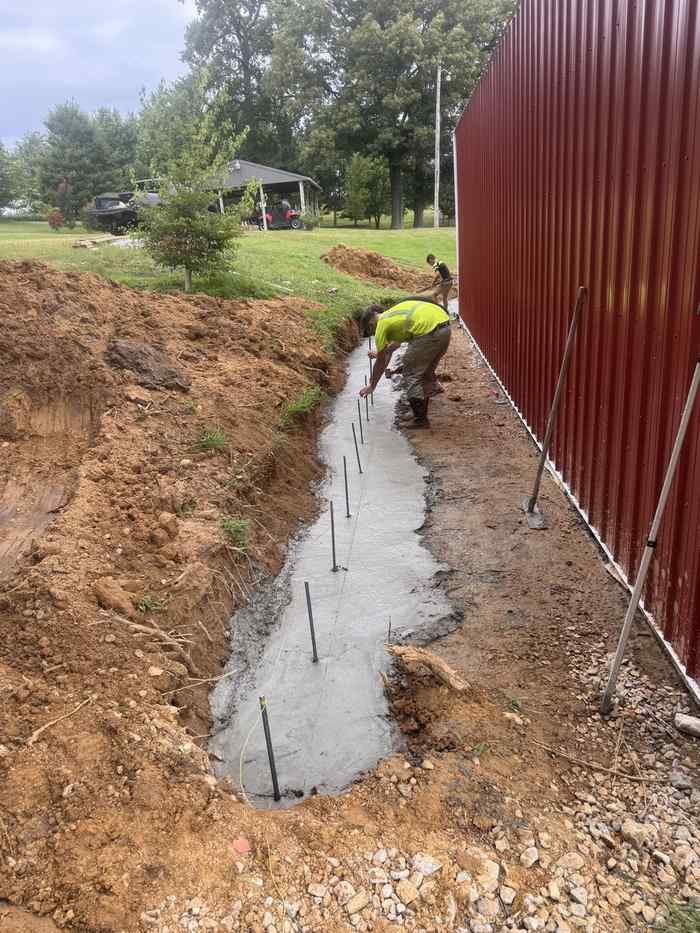 Workers setting rebar for a concrete footing