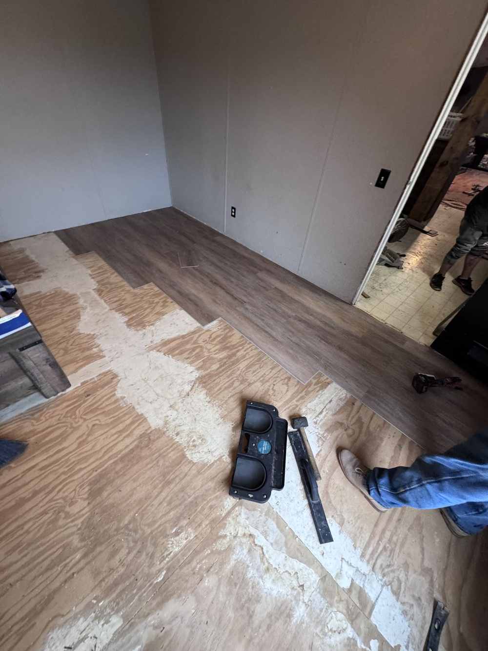 Vinyl plank flooring being installed in a bedroom