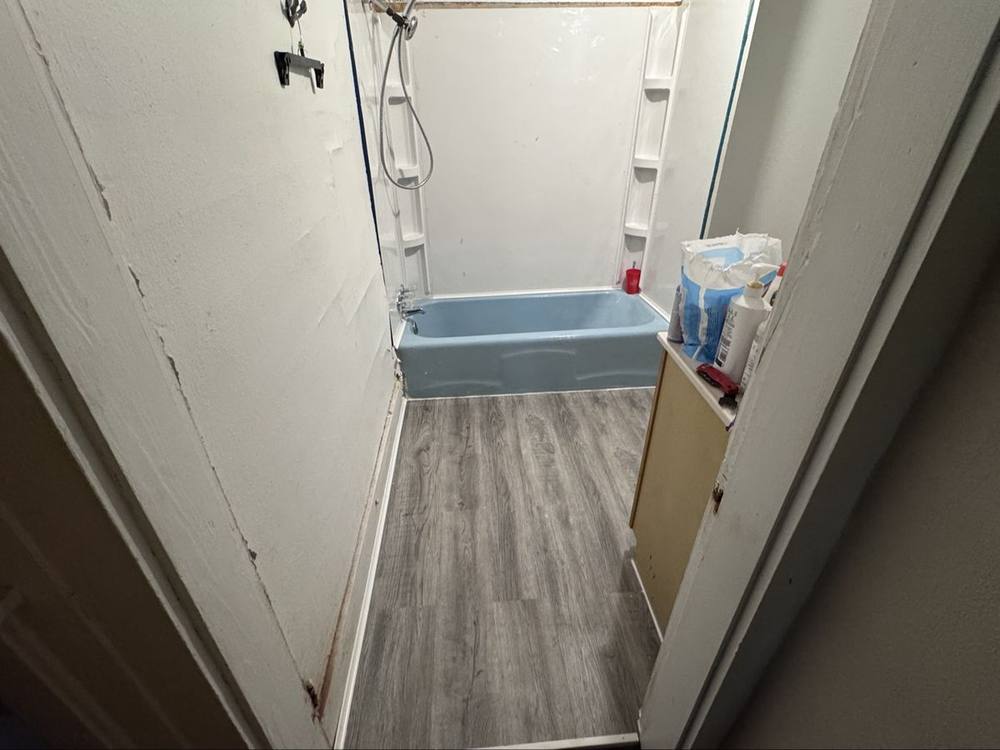 Finished bathroom vinyl plank floor by the tub