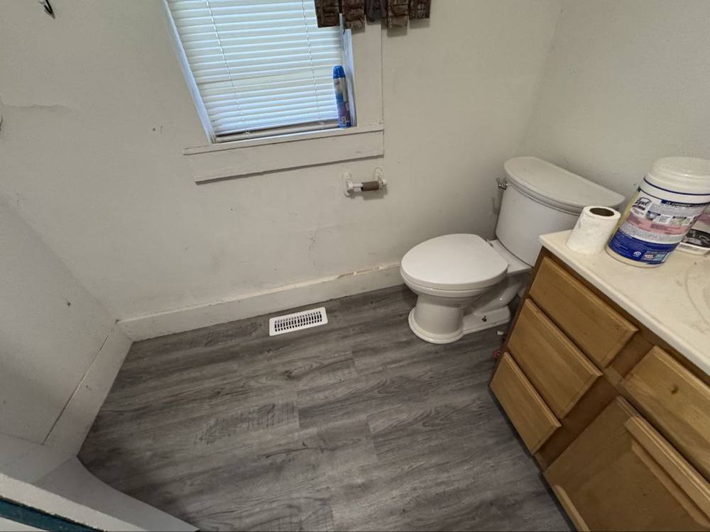 Finished bathroom with new gray vinyl plank floor