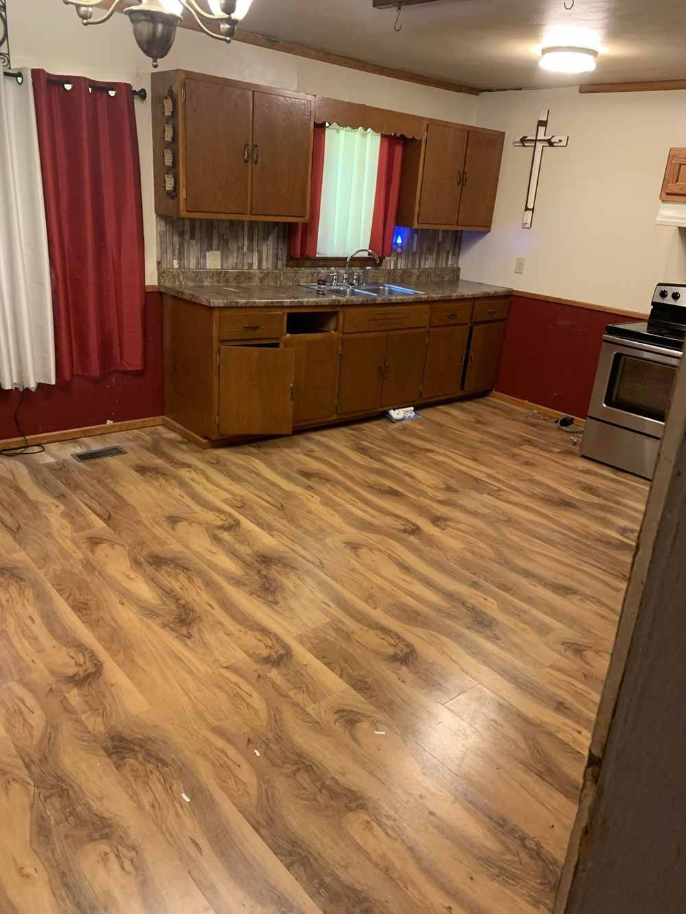 Kitchen with old wood cabinets and new vinyl plank floor going in