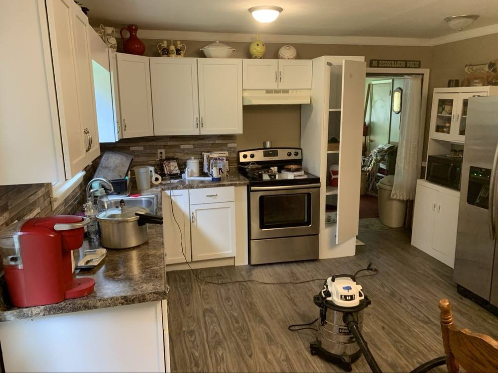 Finished kitchen with white cabinets and new flooring