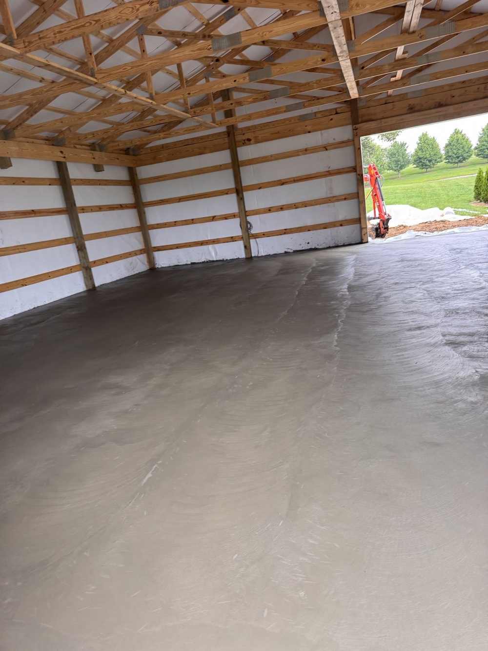 Freshly poured concrete floor inside a pole barn