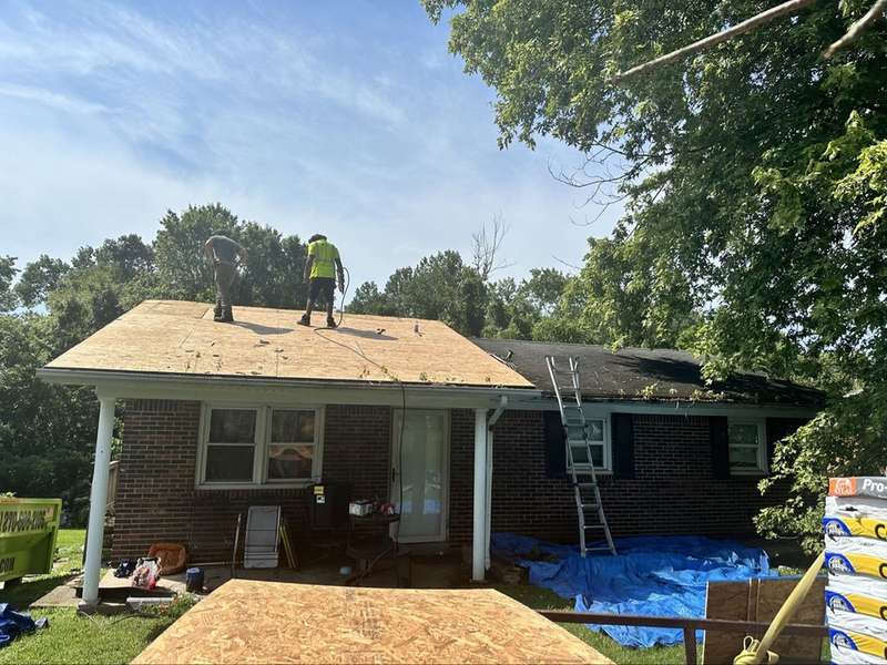 Workers tearing off an old roof down to the deck