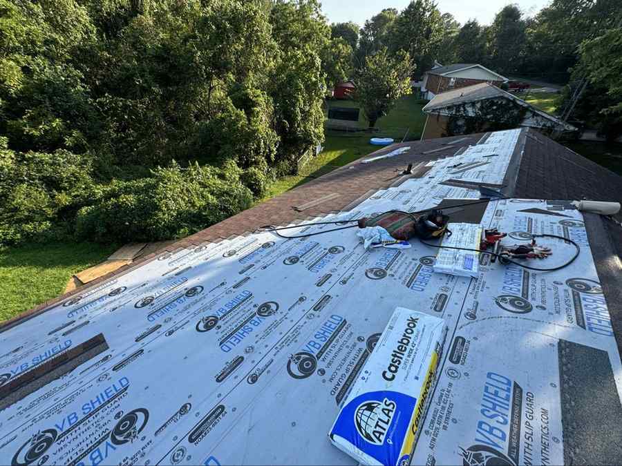 Underlayment installed with shingle bundles staged on the roof