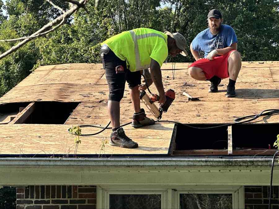Workers nailing down new roof decking
