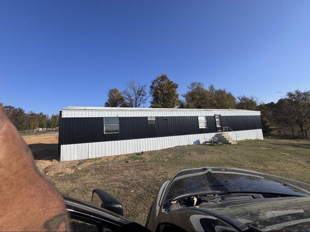 Finished home with new black and white metal siding